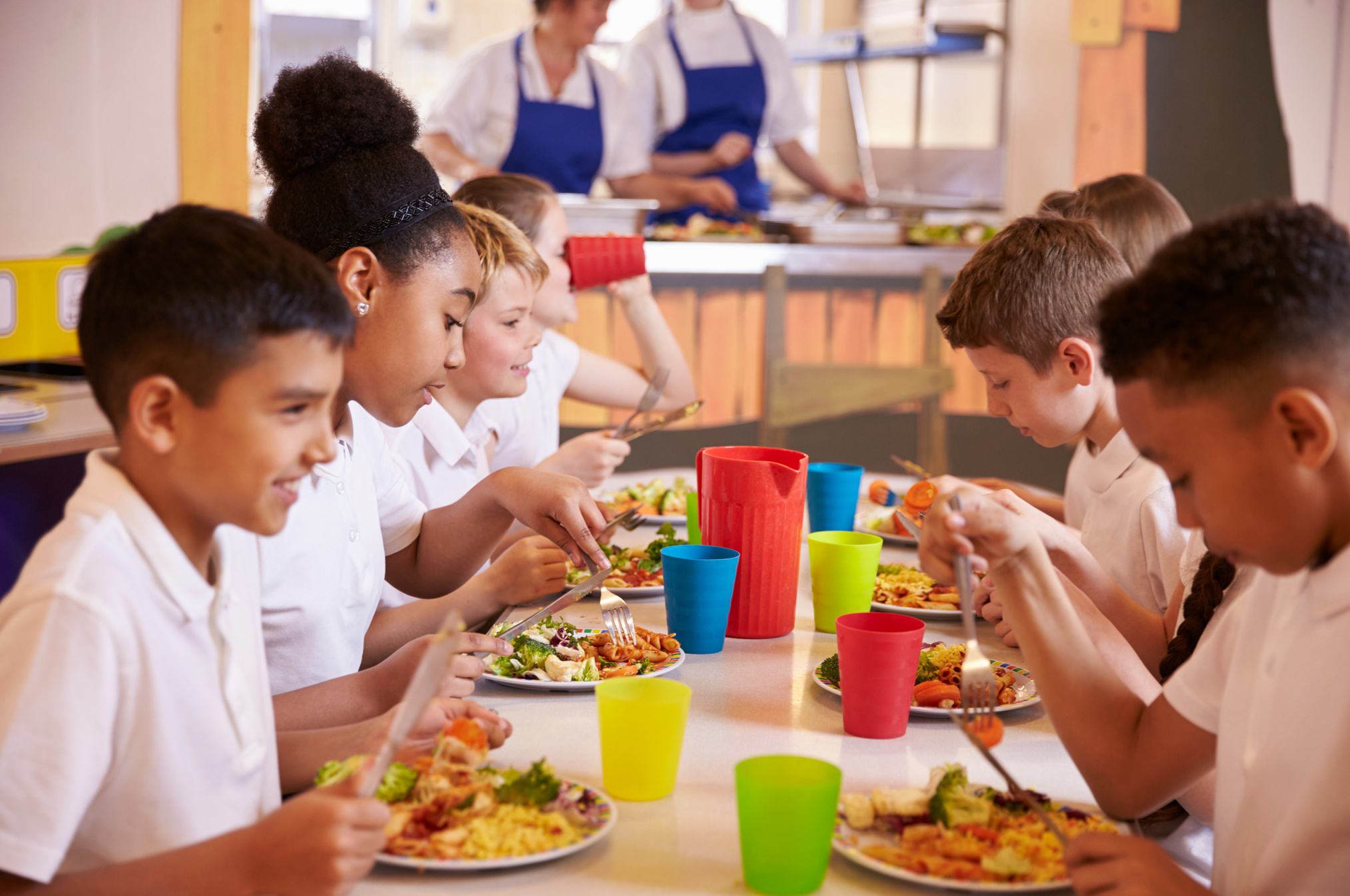 Primary School Kids Eating at a Table in School Cafeteria